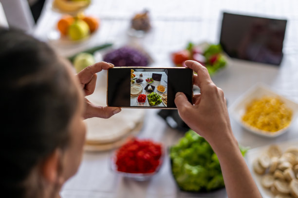 图为一名妇女在安排一项新业务时，正在用肉和蔬菜拍摄墨西哥卷饼。图片下载