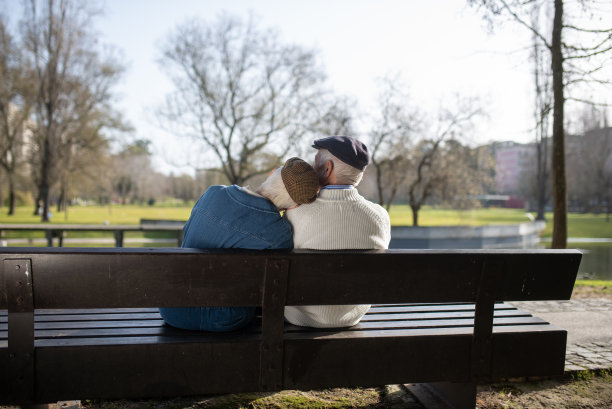 城市公园长椅上的老夫妇的后视图图片下载