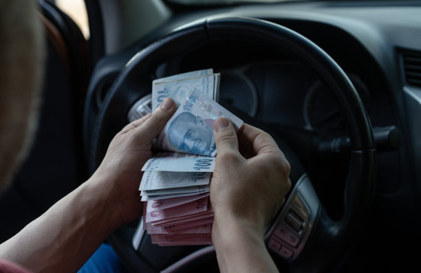 一名男子在汽车经销商的二手车前数土耳其里拉图片下载