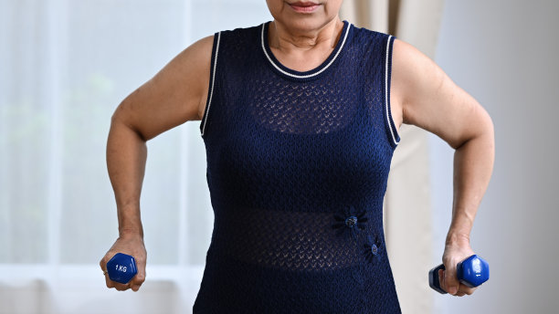 活跃的成熟女性在家用哑铃锻炼。运动积极健康有利于老年人、老年人和老年人的观念。图片下载