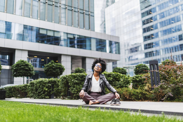 年轻的黑人女性在工作日的户外放松，背景是金融区图片下载