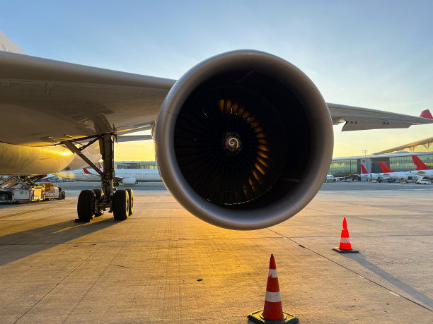 飞机发动机是前景飞机在日落时仍在停机坪水平运输图片下载