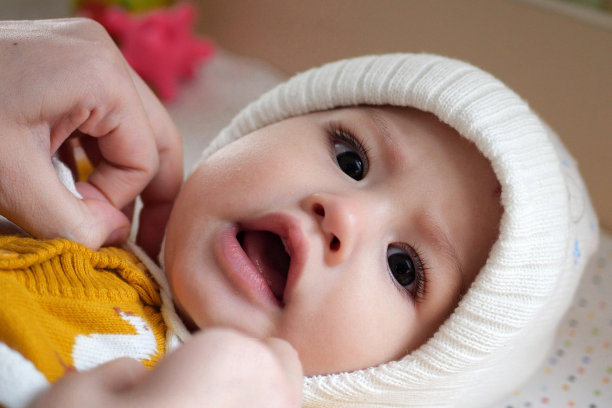 一位母亲在家里给她的小男孩穿衣服。童年为人父母和成长中家庭观念真实的人图片下载