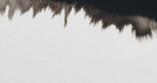 特写黑色墨边在湿纸上蔓延图片下载