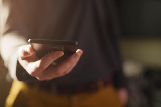 小女孩站在室内拿着智能手机图片下载