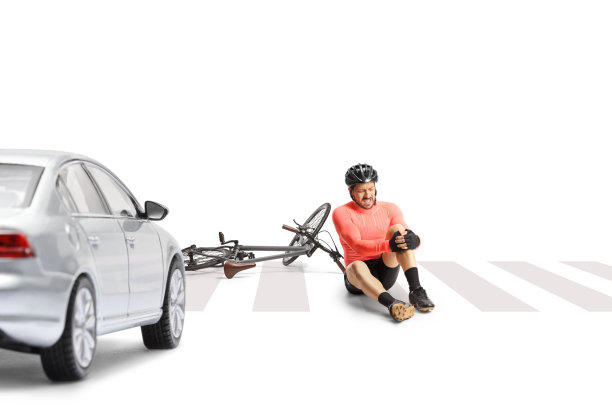 成熟的男子骑自行车坐在街上，抱着他疼痛的膝盖图片下载