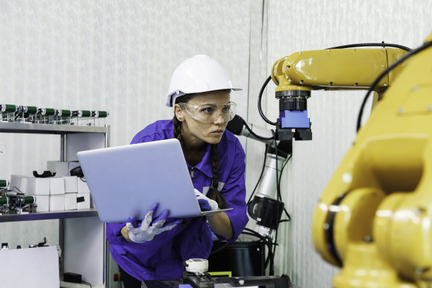 女性自动化机械工程师学生，在大学或工厂车间学习和检测控制机器人手臂机器。人工智能机器人技术是工业5.0制造业的新创新趋势图片下载
