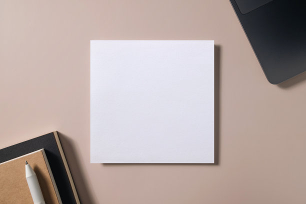 工作空间与空贺卡，笔，笔记本和笔记本电脑在米色背景。图片下载