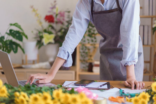 花艺概念，女花店检查客户的订单，同时在花店工作图片下载