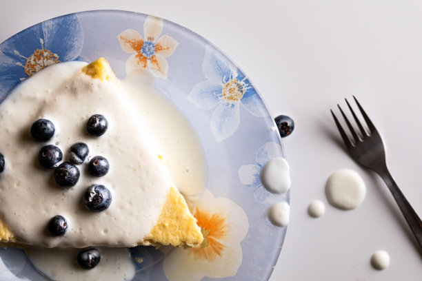 蓝盘子上的蓝莓和酸奶奶酪蛋糕的俯视图图片下载