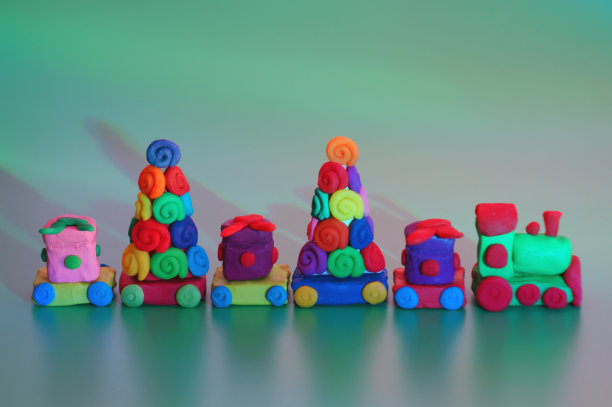 用橡皮泥做成的玩具圣诞火车，上面有礼物和圣诞树。图片下载