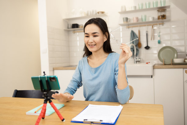 一个快乐的女人在家里拍摄视频播客的肖像图片下载