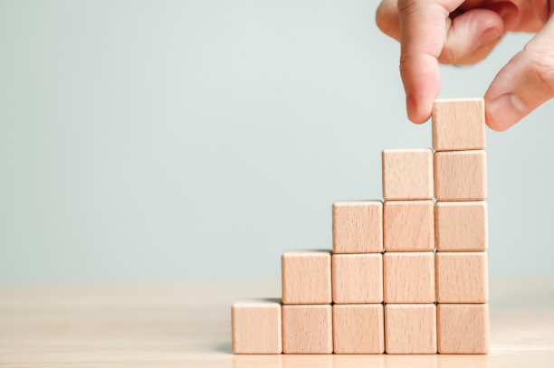 手工安排木块堆叠在木桌上作为台阶楼梯。经营理念为成长成功的过程。本空间图片下载