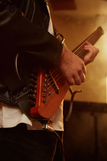 一个电吉他手正在演奏，现场，特写，背光拍摄，垂直照片图片下载