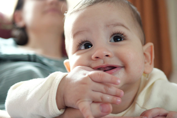 可爱可爱的新生儿在玩五颜六色的摇铃玩具。有牙齿的婴儿。六个月大的可爱的婴儿肖像在白色与牙齿玩具图片下载