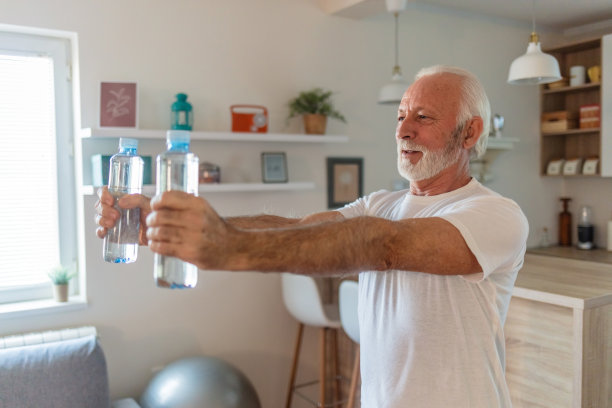 一位老人正在家里锻炼，用水瓶代替举重器械。图片下载
