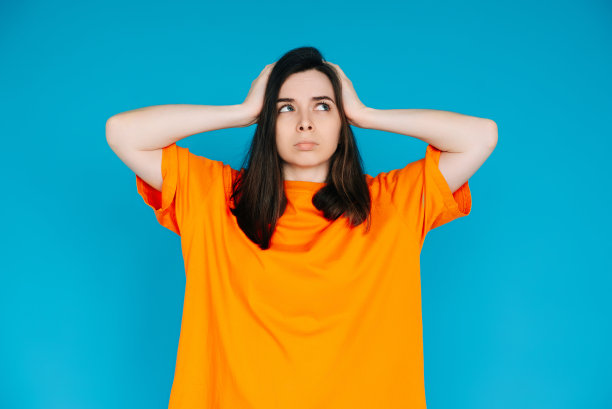 有压力的年轻女子表达不满，触摸头-负面情绪，沮丧，孤立的蓝色背景图片下载
