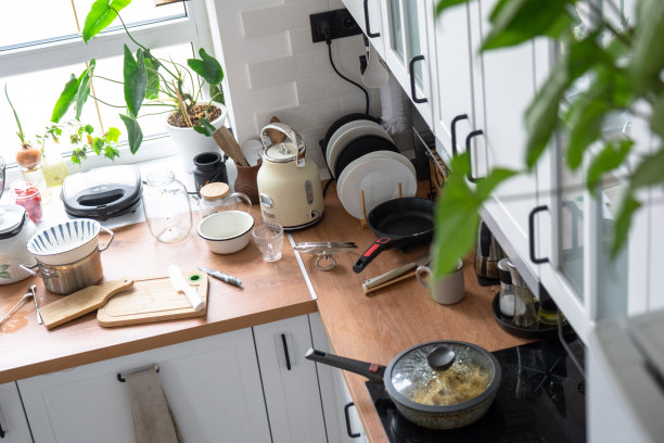 厨房里一片狼藉，桌子上的盘子很脏，东西散落，不卫生。厨房不整洁，日常生活图片下载