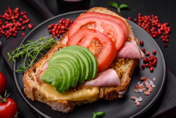 美味营养的烤面包配火腿，奶酪，西红柿和鳄梨图片下载