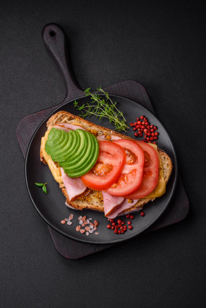 美味营养的烤面包配火腿，奶酪，西红柿和鳄梨图片下载