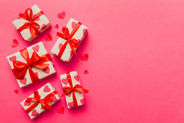 情人节装饰礼盒与红丝带蝴蝶结彩色背景的俯视图照片。假日礼盒与顶视图图片下载