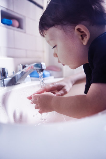 男孩在家里的浴室洗手图片下载