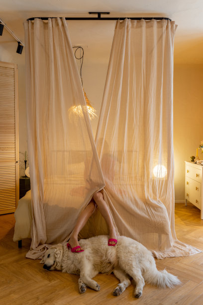 穿着粉色套装的时髦女人放松地坐在床上图片下载