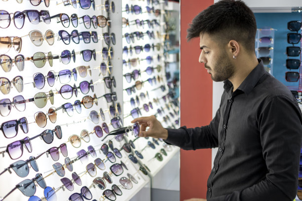 挑选太阳镜的年轻人图片下载