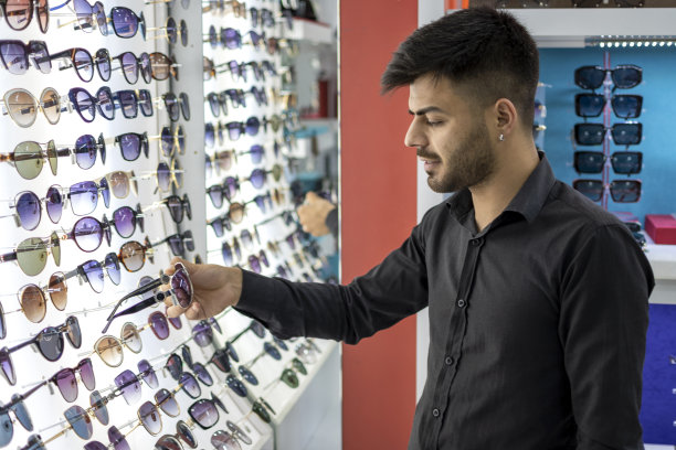 挑选太阳镜的年轻人图片下载