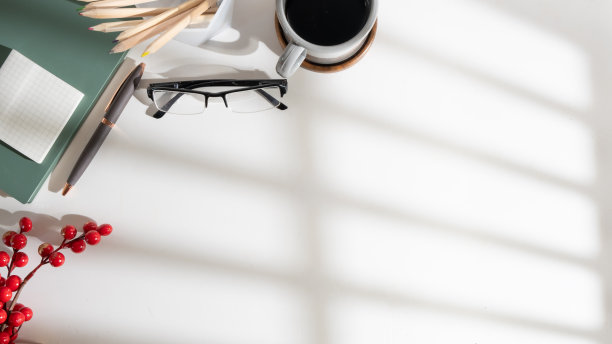 白色办公桌的俯视图，上面有笔记本、眼镜、铅笔架和一杯咖啡。为你的文本复制空间。图片下载
