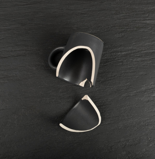 采购产品破碎的杯子，黑色陶瓷杯件，在黑色背景上破碎的杯子图片下载