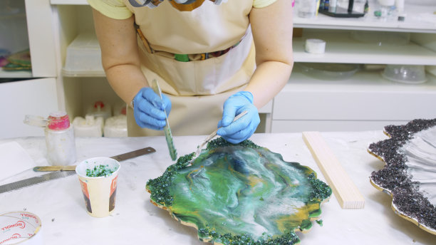 匠人在创意工坊用闪光装饰绿色树脂制品图片下载