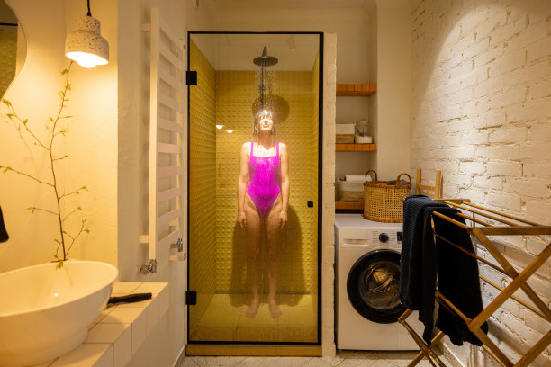 穿着粉色泳衣的女子在淋浴间淋浴图片下载