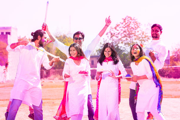 一群兴高采烈的印度年轻人在户外公园庆祝胡里节，一起玩得很开心，顽皮的成年男性和朋友们脸上涂着五颜六色的油漆在玩古拉尔。图片下载