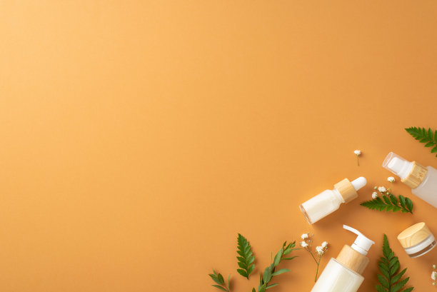 天然草本化妆品概念。上面的图片是蕨类植物和桉树的叶子，gypsophila花和化妆品容器的一面在孤立的棕色背景与copyspace图片下载