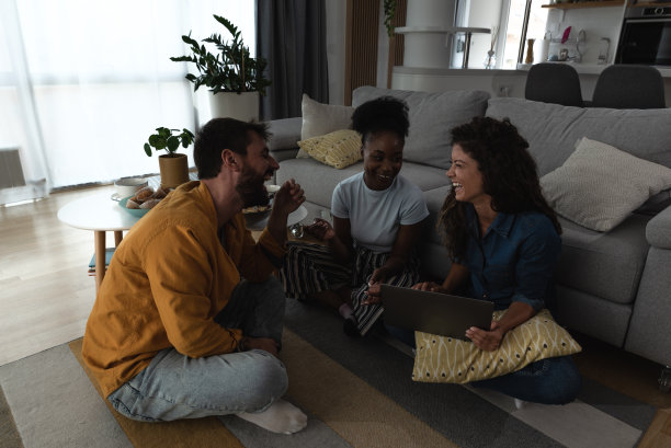 一群自由职业者商业伙伴同事在家里用笔记本电脑工作。三个营销专家在公寓家庭办公室冷却和工作的新项目。图片下载