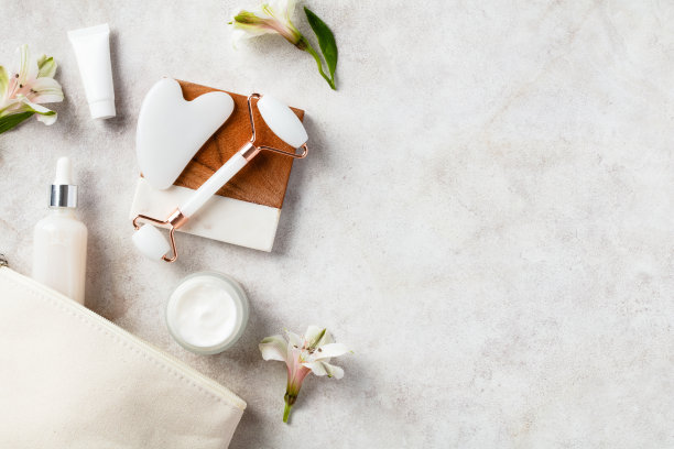 含天然美容产品的面部护肤化妆包。平铺，俯视图面辊，刮痧，面霜保湿，精华液。图片下载