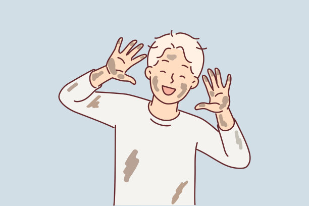 青春期前的小脏男孩笑着，露出沾满泥坑泥土的手掌和脸图片下载