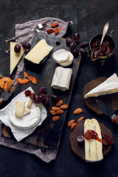 奶酪板在黑暗的背景。图片下载