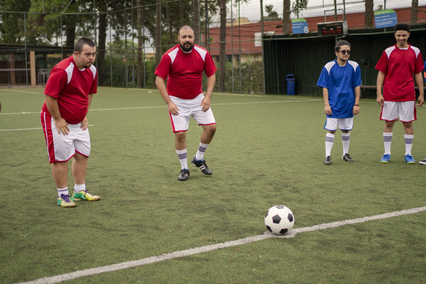 患有唐氏综合症的足球运动员准备踢球图片下载