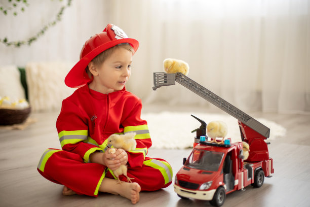 在家玩消防车玩具和小鸡的小男孩图片下载