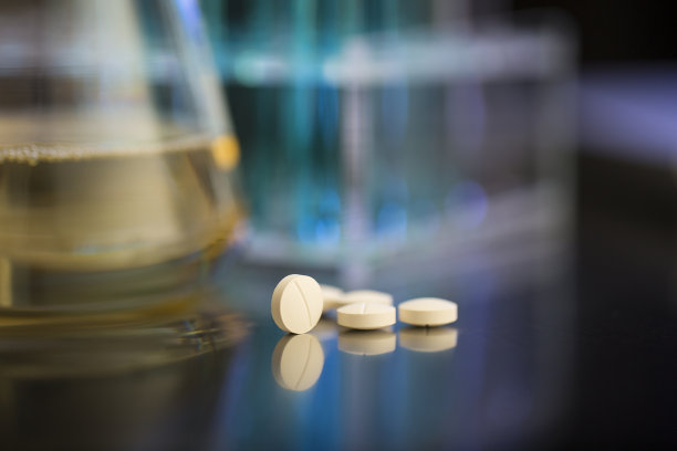 淡黄色药丸在测试实验室桌子-库存照片图片下载