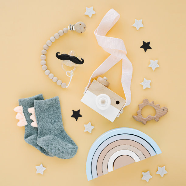 木制玩具，袜子和彩虹为新生儿的黄色背景。一套婴儿用品和配件。平铺，俯视图图片下载