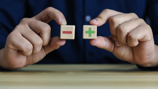 拿起带有红色和绿色正负号的立方体符号。图片下载