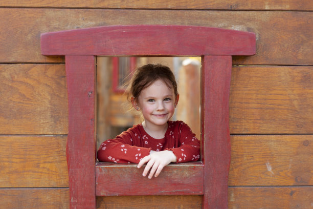 一个可爱的小女孩在木屋前的肖像图片下载