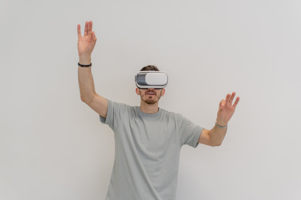 戴着虚拟现实眼镜的未来派男子在一个孤立的灰色背景中与空气互动。图片下载