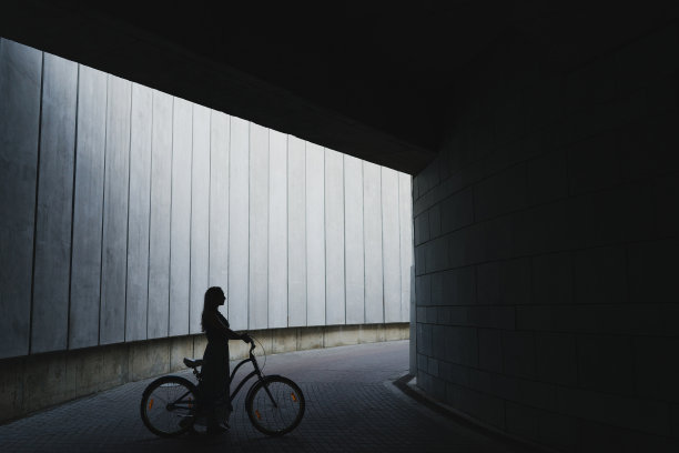 活跃时尚的金发女人与一个城市背景的复古自行车。图片下载