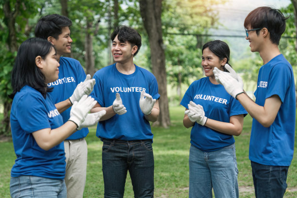 一群年轻的志愿者鼓掌庆祝他们成功的慈善活动图片下载