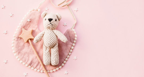 围嘴和木制玩具。一套婴儿用品和配件的女孩在粉彩粉红色的背景。婴儿洗澡的概念。时尚的新生儿。平铺，俯视图图片下载