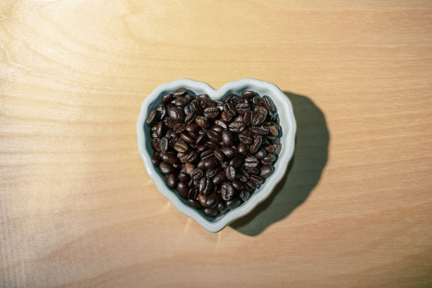 心形白色碗里的咖啡豆图片下载